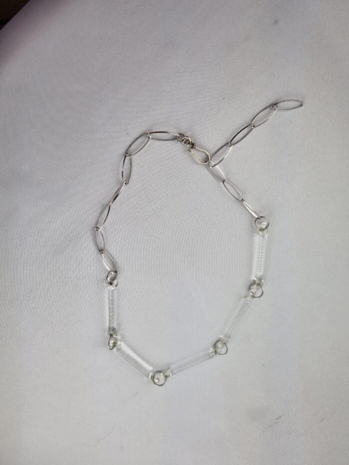 Silberkette mit 5 klaren Stäbchen aus Glas liegend