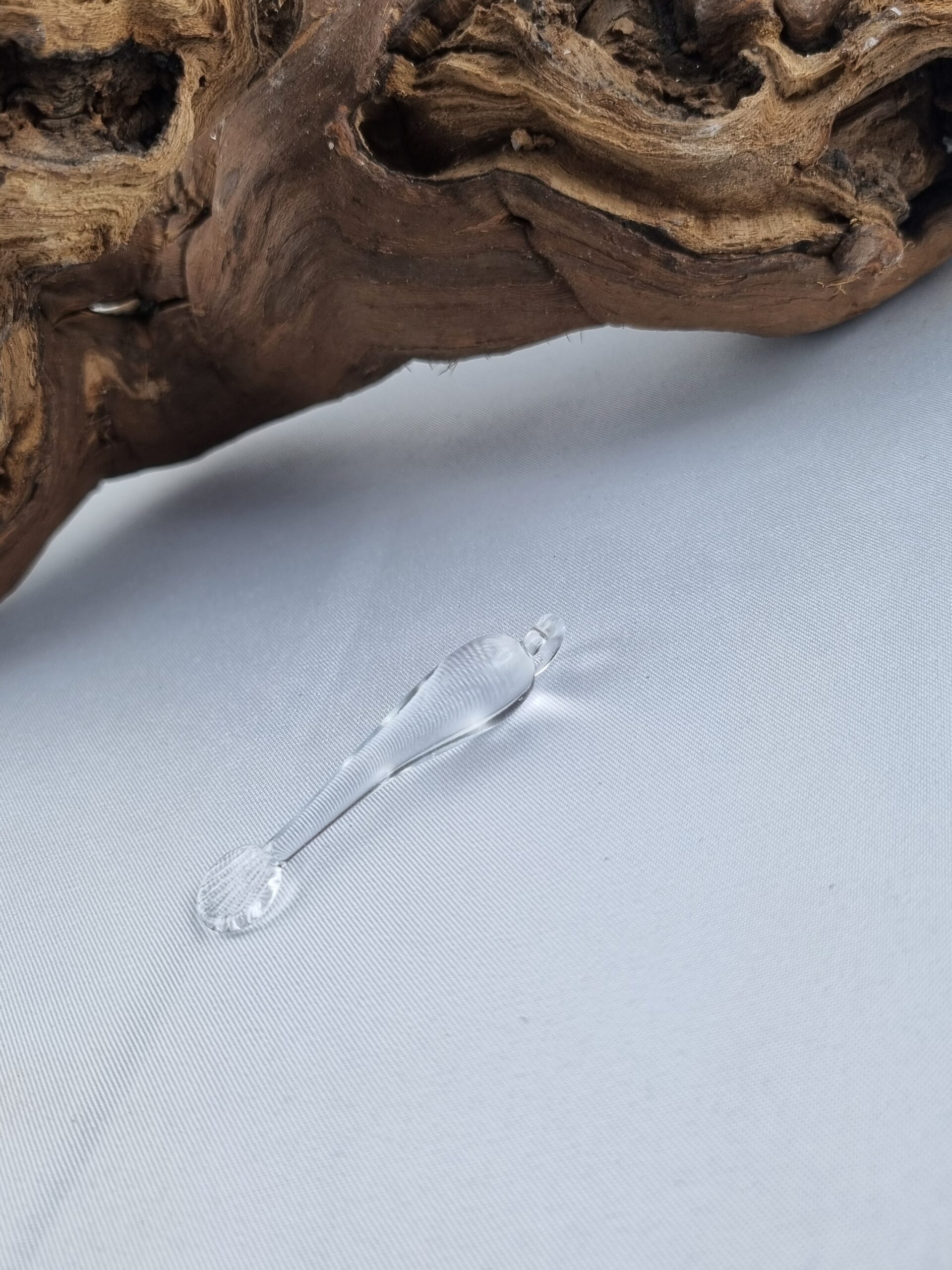 Anhänger minimalistischer Fisch aus klarem Glas liegend