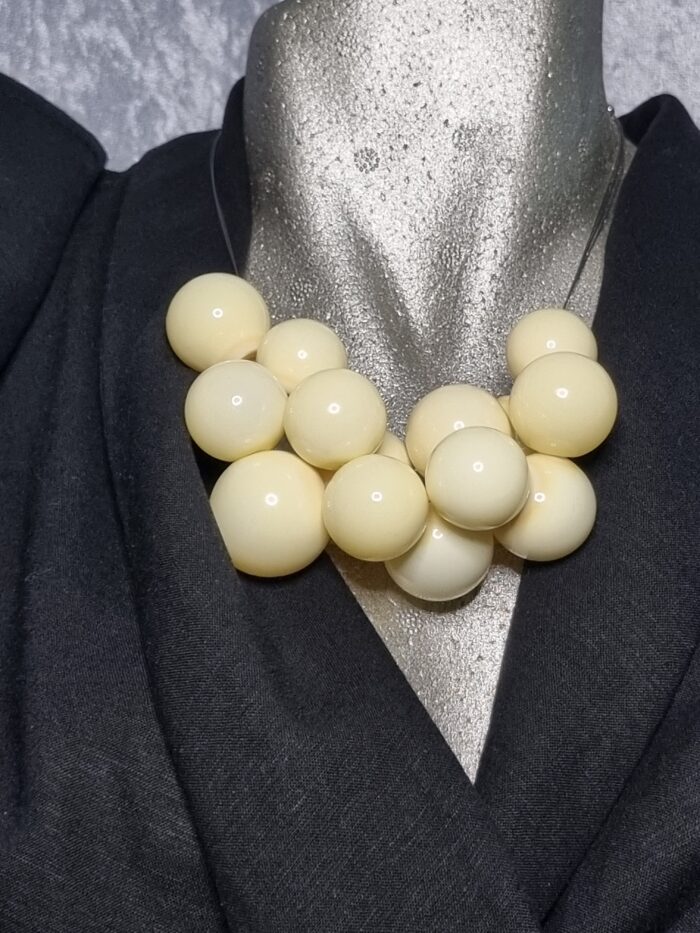 e Edelstahlseil mit 15 buttergelben runden Glas Hohlperlen auf Styroportorso schwarz bekleidet