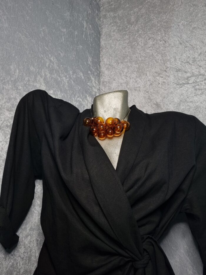 e Edelstahlseil mit 15 transparent Topaz färbigen runden Glas Hohlperlen auf Styroportorso schwarz bekleidet